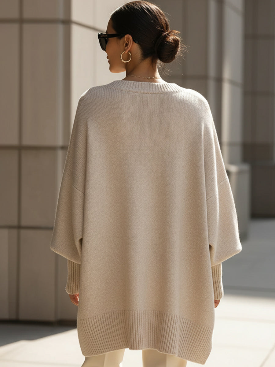 Achterkant van de beige poncho gedragen door een model, met brede geribbelde onderrand 5
