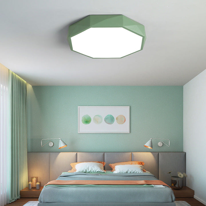 Groene achthoekige plafondlamp boven een slaapkamer met bed, groene muur en twee wandlampen 20