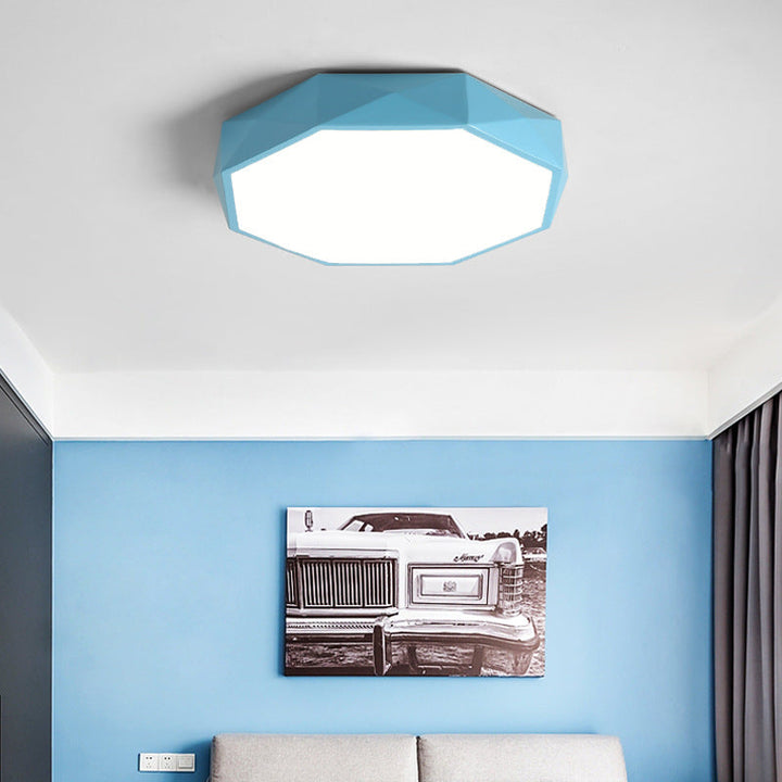 Blauwe achthoekige plafondlamp aan het plafond van een kamer met blauwe muur en zwart-wit schilderij 3