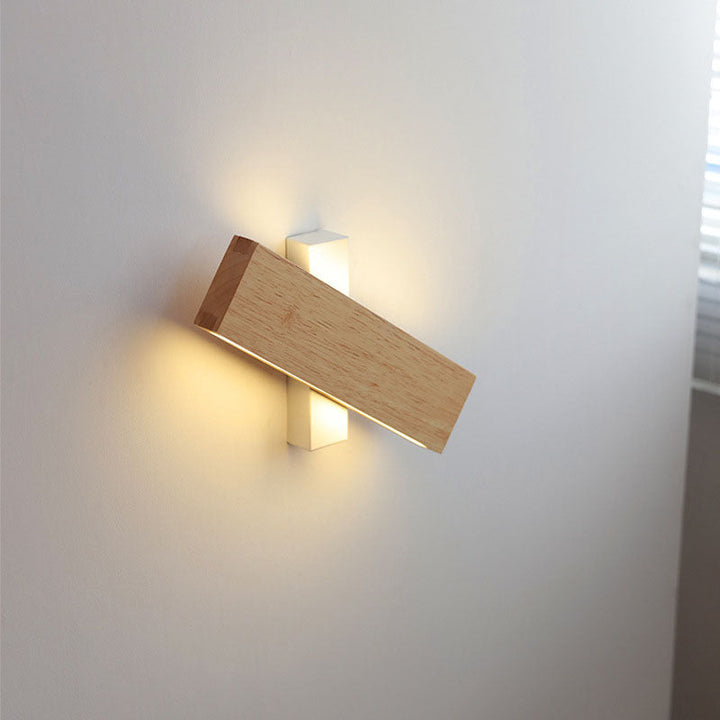 Houten wandlamp met witte bevestiging, dwars gedraaid en brandend, waarbij licht boven en onder de witte steun schijnt. 9