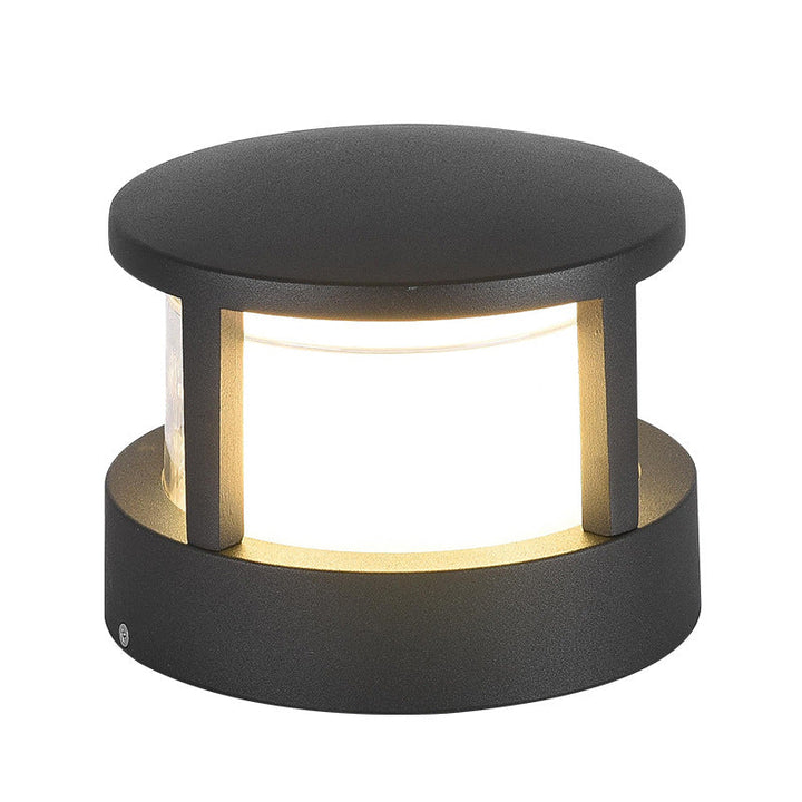 Ronde zwarte lamp met overstekend dak en brede voet, van dichtbij gefotografeerd met warm licht door het matte glas. 12