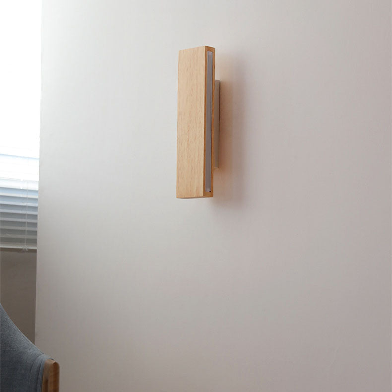 Uitgeschakelde houten wandlamp, verticaal gemonteerd aan de muur, zijaanzicht naast een raam met jaloezie. 2