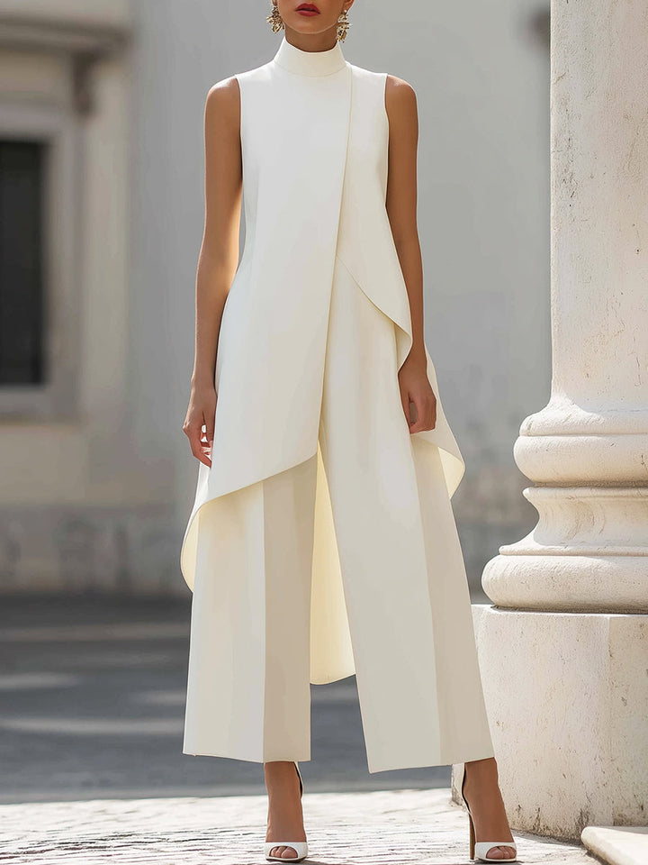 Crèmewitte set met mouwloze asymmetrische top en wijde broek, gedragen door een model naast een witte zuil. 3