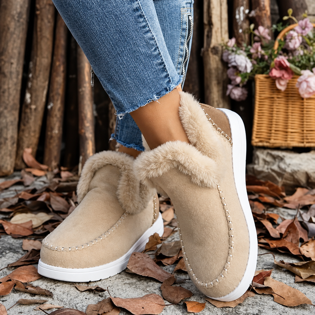 Beige instapsneakers met pluchen rand en witte zool, gedragen met spijkerbroek, voor- en zijaanzicht tussen herfstbladeren. 9