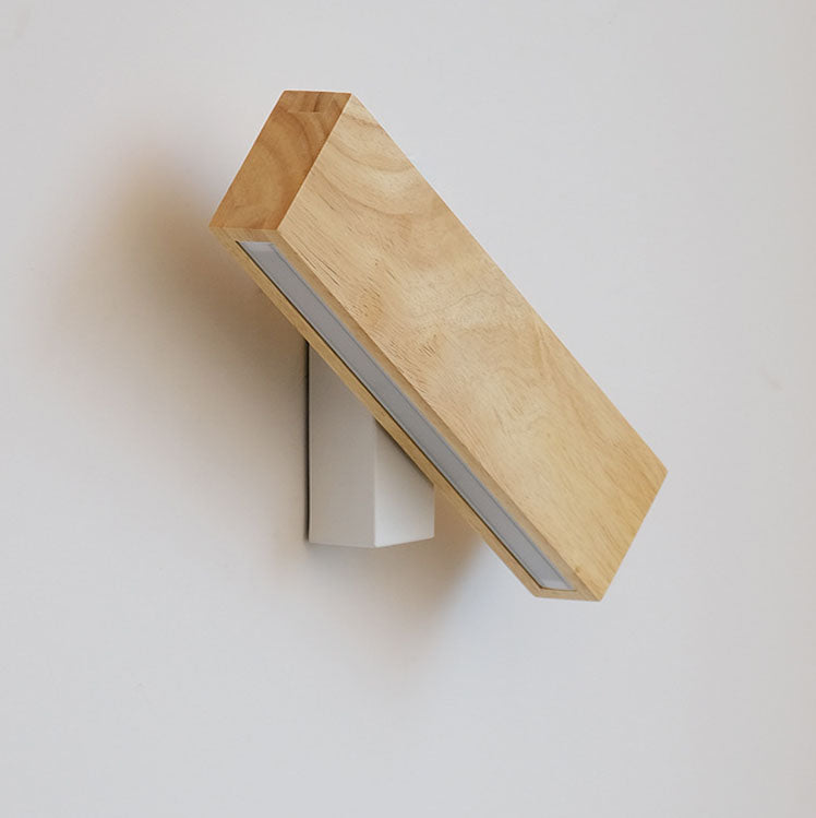 Uitgeschakelde houten wandlamp schuin gedraaid op de witte bevestiging, met zicht op de houtnerf en de matte lichtstrip. 13