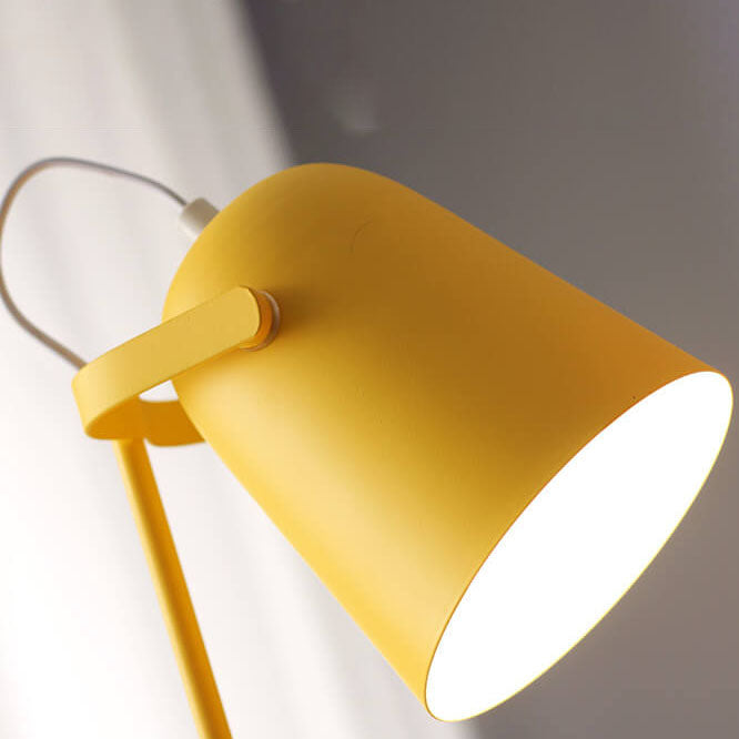 Close-up van de gele lampenkap van onderaf, met het verstelbare scharnier en het witte licht binnenin. 2