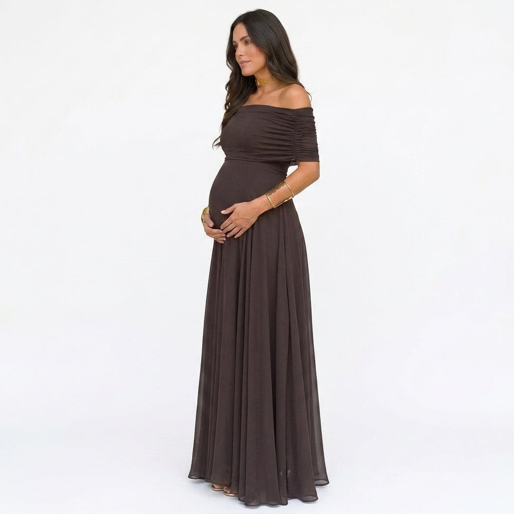 Zijaanzicht van de donkerbruine off-shoulder jurk, met de hand om de babybuik, het vloeiende rokdeel valt wijd 2