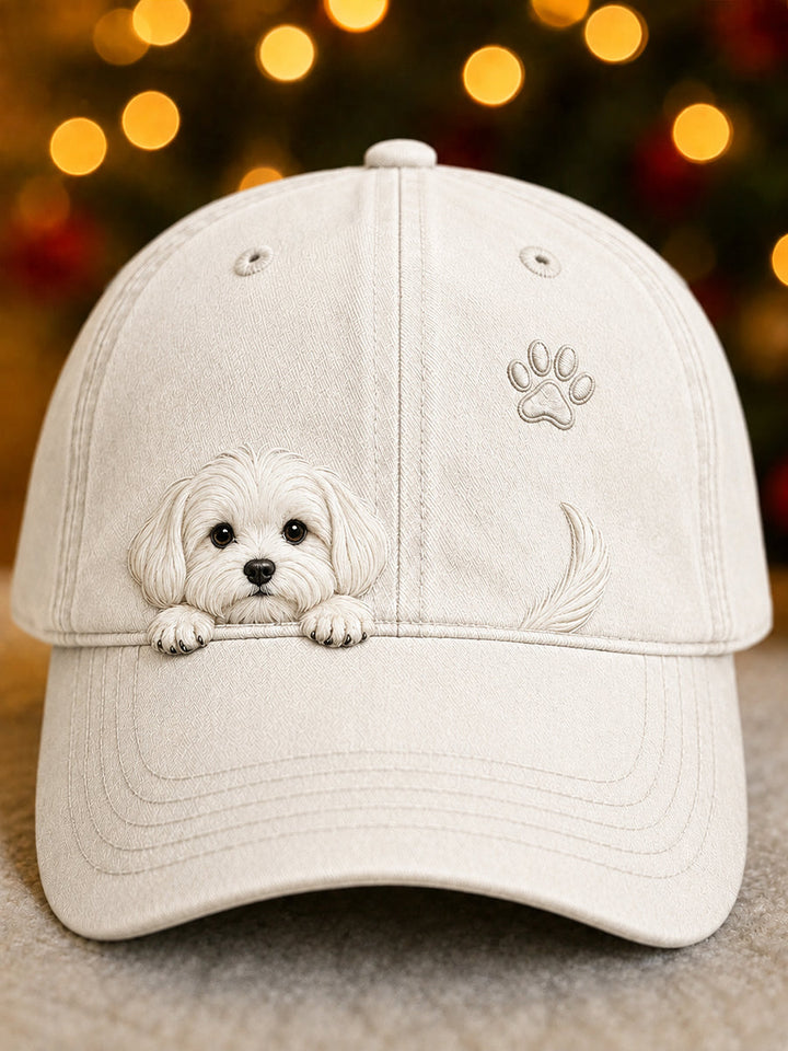 Voorkant van de baseballpet in crème met een geborduurd hondje dat over de rand kijkt, een pootafdruk en een staartje 1