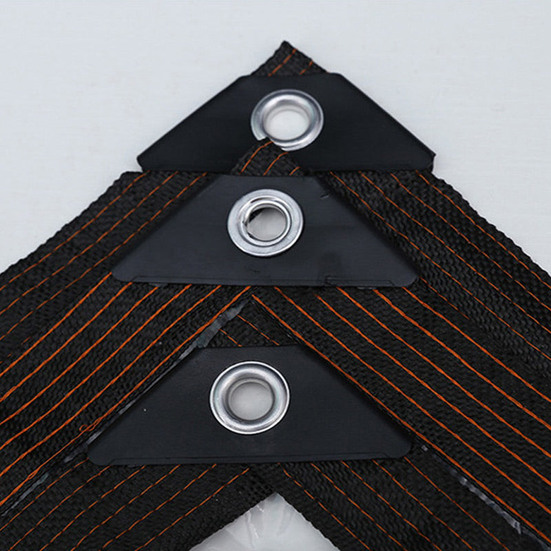 Detail van een hoek met drie metalen ogen op zwarte versterkingen en de geweven rand met oranje stiksels. 5