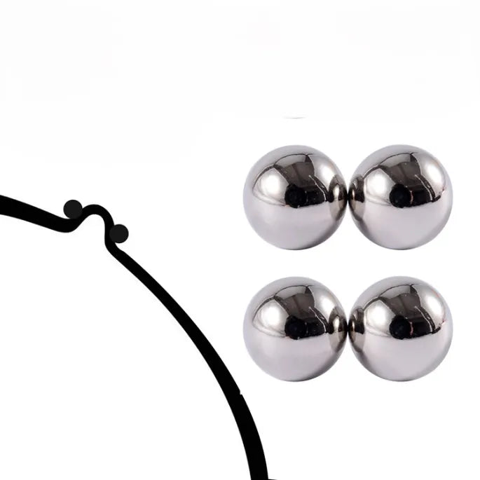 Twee paar zilverkleurige glanzende magneetbolletjes naast een zwarte getekende lijn met twee kleine bolletjes, op een witte achtergrond. 6