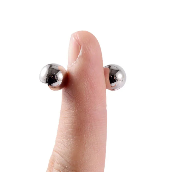 Duim met aan weerszijden een zilverkleurig bolletje dat door magnetisme vastzit, ter illustratie van de klemwerking. 7
