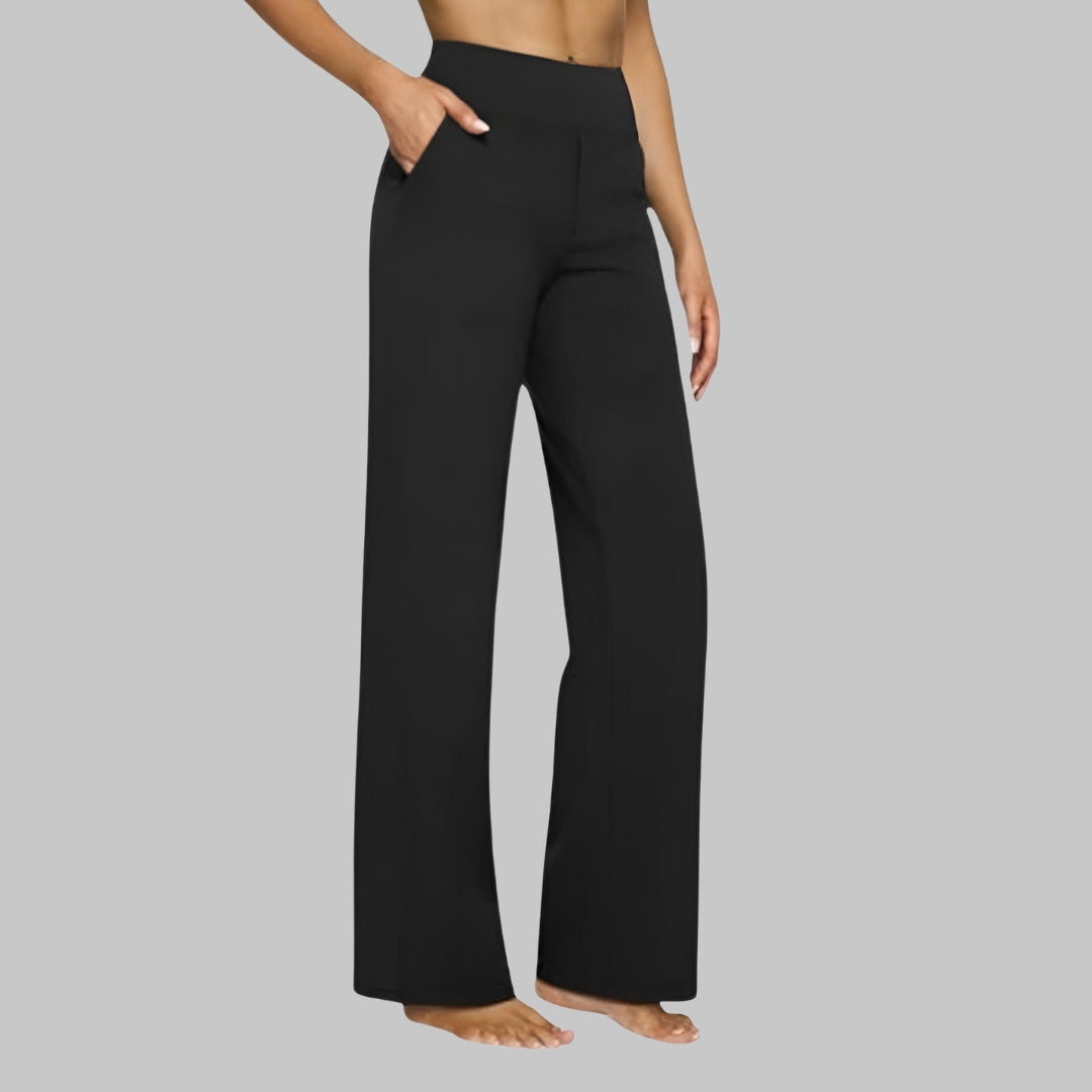 Model in zwarte broek met hoge taille en rechte pijp, zijaanzicht met een hand in de zak. 9