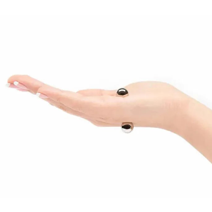 Zijaanzicht van een open hand met twee zilverkleurige bolletjes aan boven- en onderkant van de vingers, magnetisch bevestigd. 9