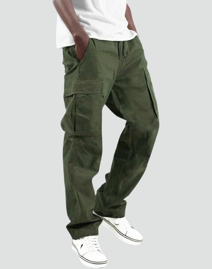 Model draagt legergroene cargobroek met zijzakken, trekkoord in de taille en wit T-shirt, schuin van voren gezien met witte sneakers. 1