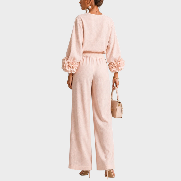 Achteraanzicht van model in roze set met bloemen aan de mouwen en gesmockte tailleband 8