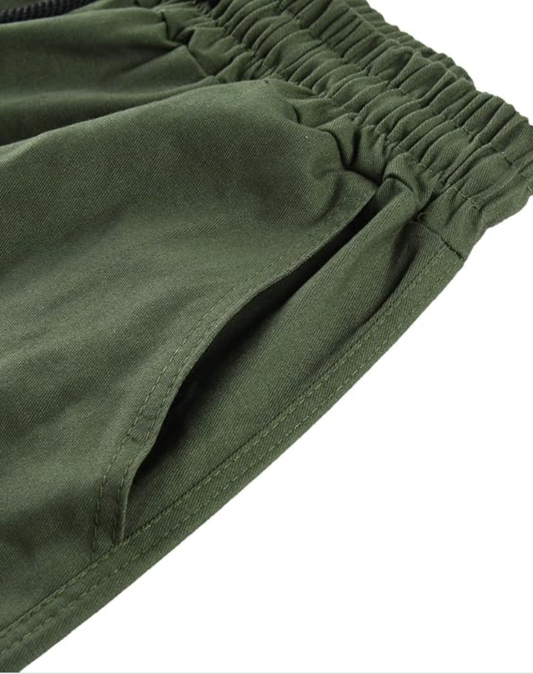 Close-up van de elastische taille en de schuine steekzak van de legergroene cargobroek, met zichtbare stiksels. 13