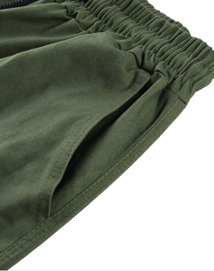 Close-up van de elastische taille en de schuine steekzak van de legergroene cargobroek, met zichtbare stiksels. 13