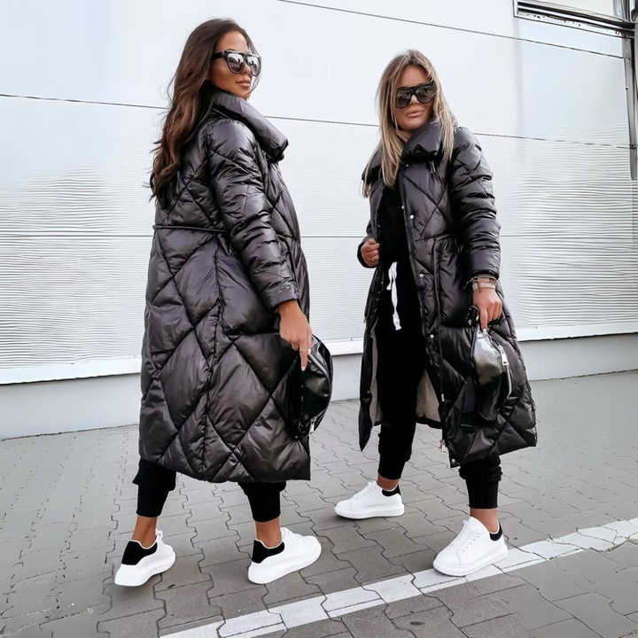 Twee vrouwen in de zwarte, gewatteerde lange jas met ruitpatroon, de ene van opzij en de andere van voren, met witte sneakers. 4