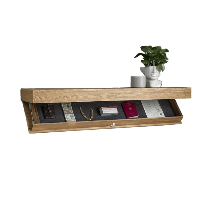 Muurplank in lichte houtnerf met open verborgen vak waarin portemonnee, geld, gouden armband en paspoort liggen, met plant en kopje erbovenop. 3