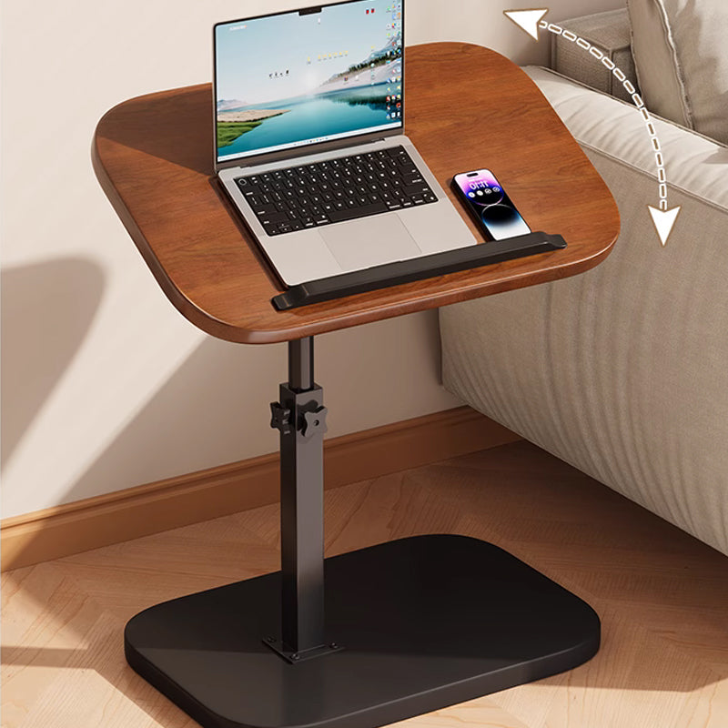 Bruin laptopbureau naast een bank met laptop en telefoon op het blad, en een gebogen pijl die de kantelbeweging van het blad toont. 2