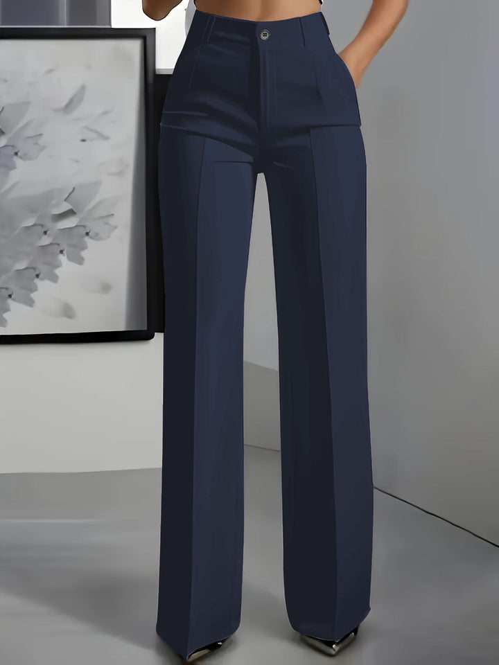 Voorkant van een marineblauwe broek met hoge taille en wijde pijpen, gedragen door een model 1