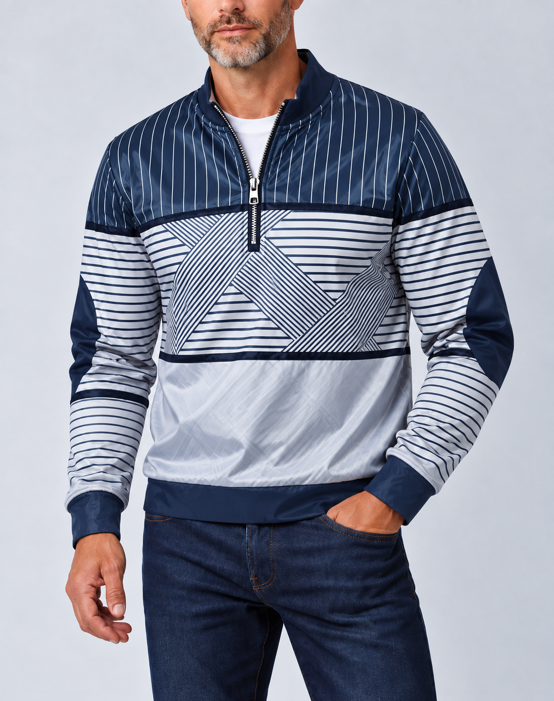 Man met grijze baard draagt de marineblauw-witte gestreepte pullover met halve ritssluiting, een witte trui eronder en een donkere spijkerbroek, voorkant. 1