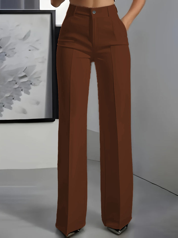 Voorkant van een roestbruine broek met hoge taille en wijde pijpen, gedragen door een model 6