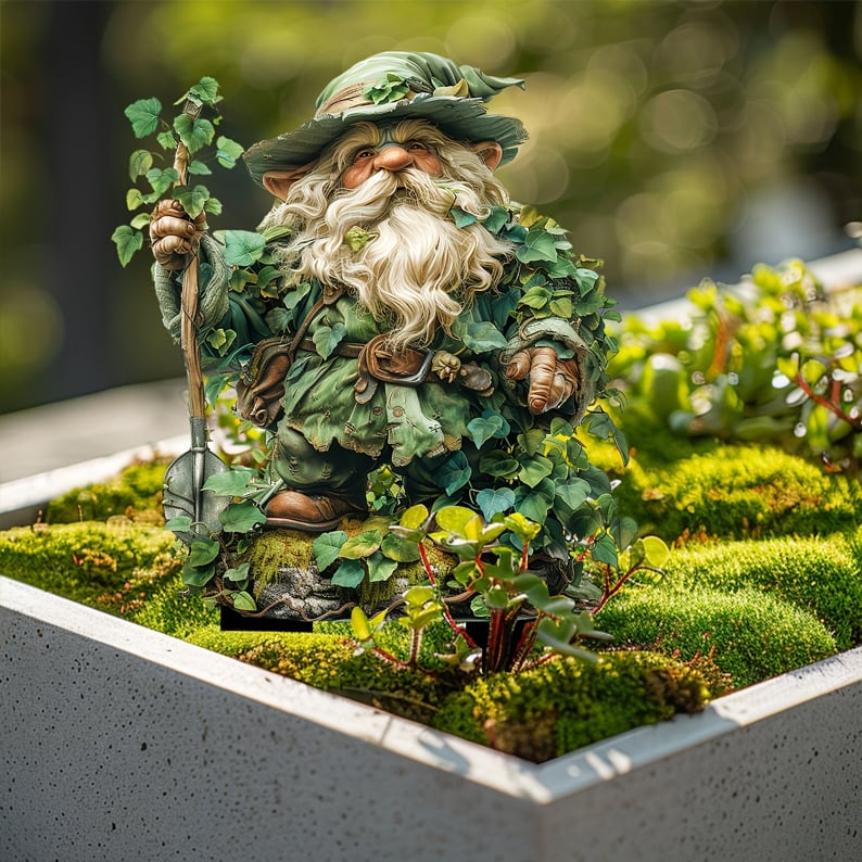 Tuinkabouter met klimopblaadjes en schep, geplaatst in een betonnen plantenbak met mos en een vetplant op de voorgrond. 15