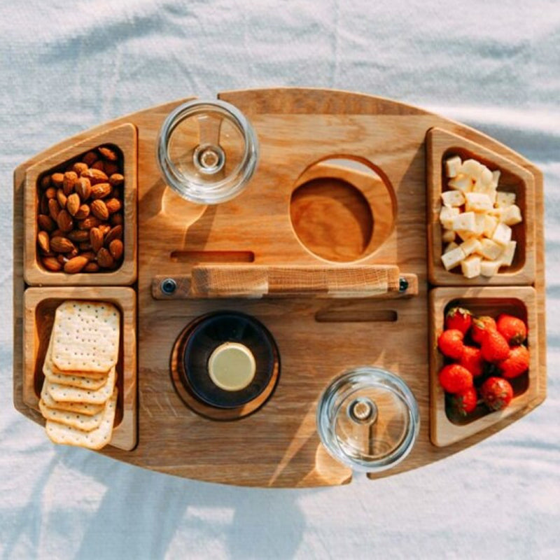 Bovenaanzicht van de houten wijntafel met amandelen, crackers, kaas, aardbeien, twee glazen en een fles 5