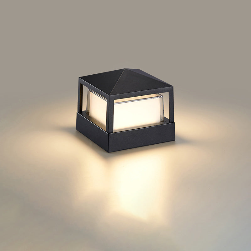 Vierkante zwarte lamp met piramidedak en warm gloeiend scherm, vrijgesteld op een neutrale achtergrond. 10