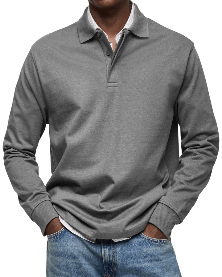 Voorkant in middengrijs: model draagt het shirt over een wit gestreept overhemd, met ribboorden bij de polsen. 6