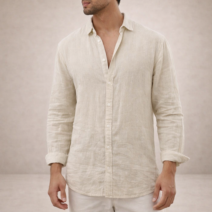 Beige linnen overhemd met kraag en opgerolde mouwen aan een model, met een lichte broek, hoofd deels buiten beeld. 6