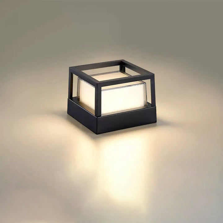 Vierkante zwarte lamp met open kubusvormig frame en warm gloeiend scherm op neutrale achtergrond. 11