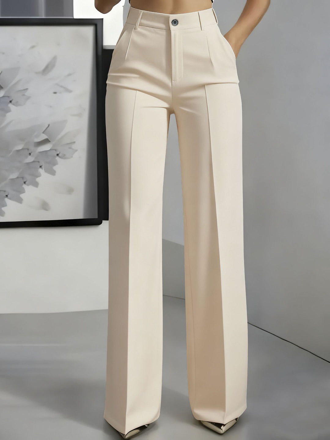 Voorkant van een crèmekleurige broek met hoge taille en persplooi, gedragen met een hand in de zak 5