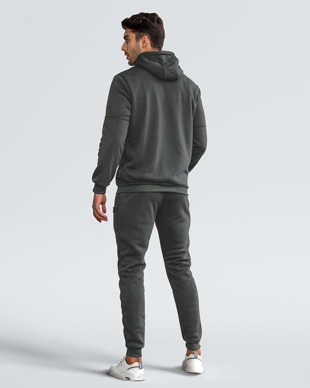 Model in grijs trainingspak van achteren gezien, met capuchon, geribbelde boord en joggingbroek met boorden om de enkels 9