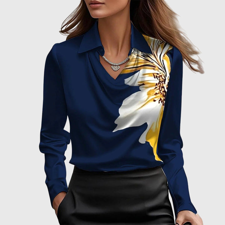 Model draagt de marineblauwe blouse met grote witgele bloemprint op de schouder, gedrapeerde hals en een zwarte rok. 8