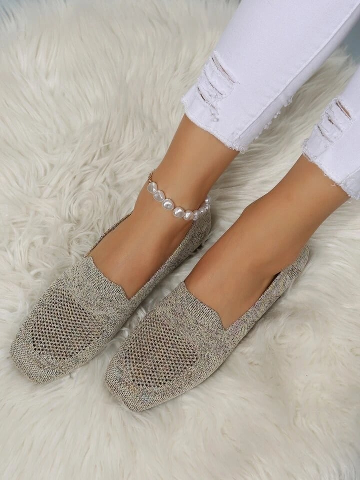 Beige mesh instapschoenen met open neus gedragen op een wit pluizig kleed, met witte gescheurde jeans en parelenkelbandje. 20