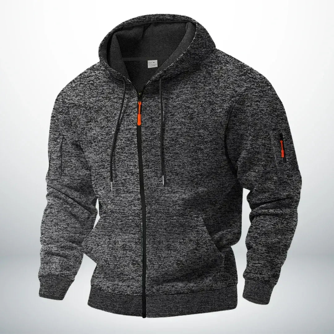Hoodie in gemêleerd donkergrijs met capuchon, zwarte rits en oranje details, schuin van voren op een neutrale achtergrond. 5