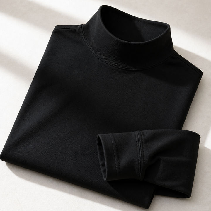 Opgevouwen zwart shirt met opstaande ribkraag en een omgeslagen mouw, van dichtbij gefotografeerd op een lichte ondergrond. 5