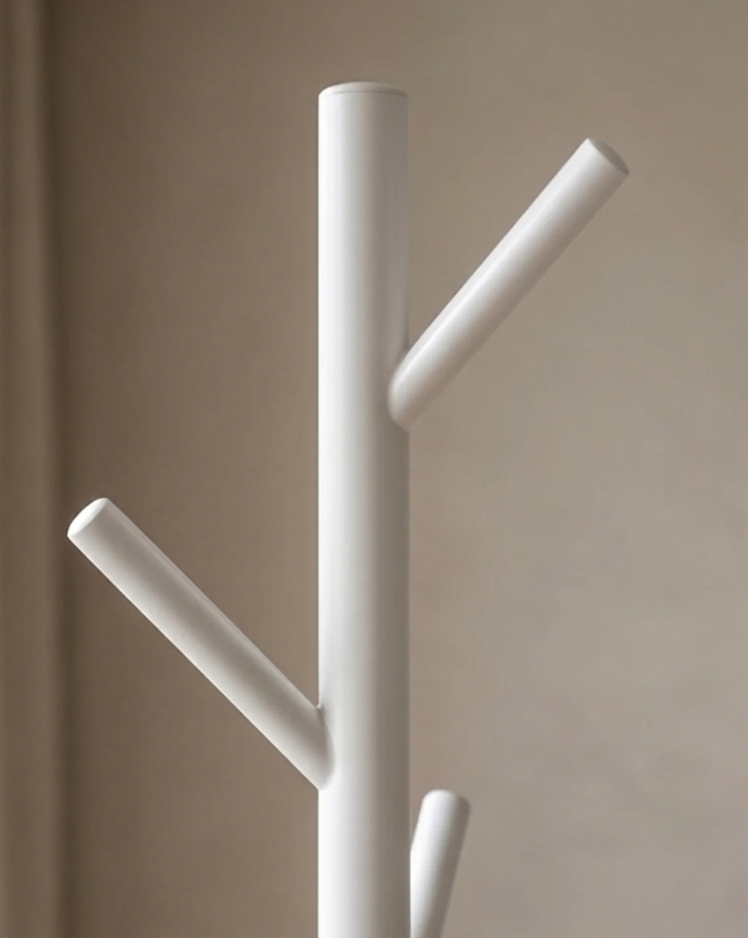 Close-up van de bovenkant van de witte kapstok, met de afgeronde top en twee schuin omhoog wijzende haken. 5