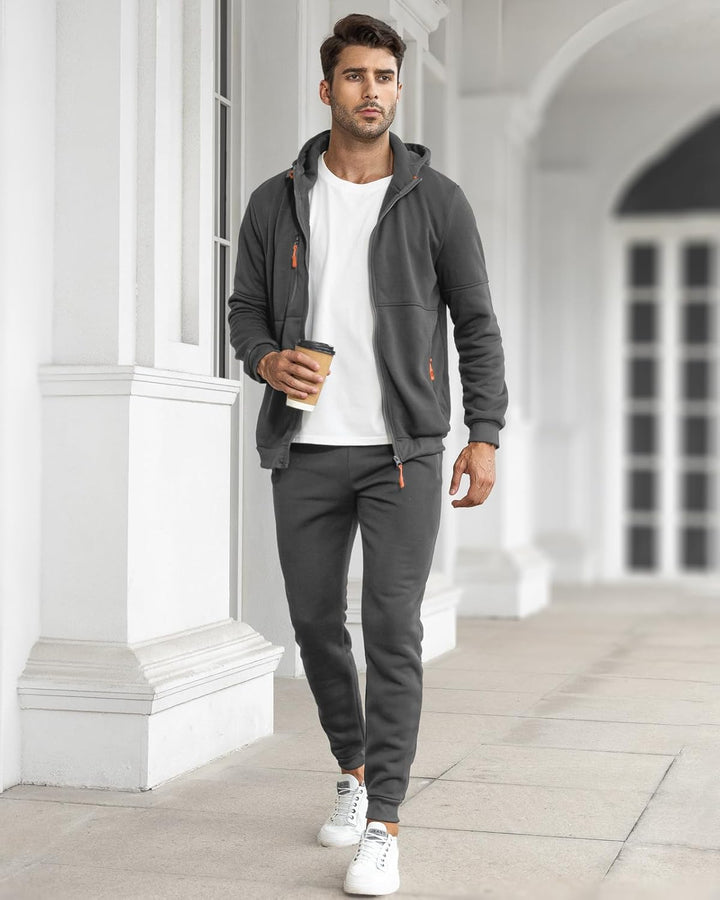 Model loopt met koffie in de hand, grijs vest open over wit T-shirt, met bijpassende joggingbroek en witte sneakers 12