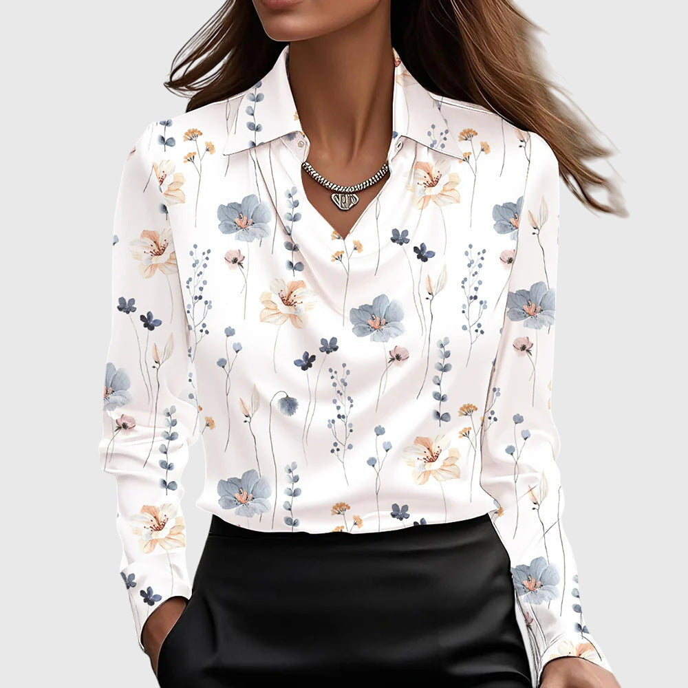 Model draagt de witte blouse met fijne bloemenprint in blauw en perzik, gedrapeerde hals, kraag en een zwarte rok. 9