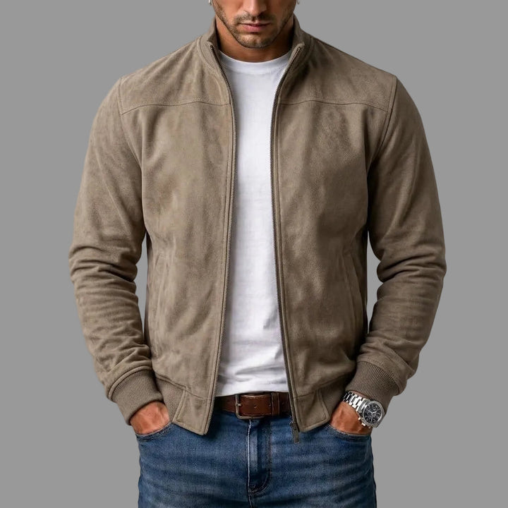 Taupe suèdelook jack, open gedragen over een wit T-shirt en jeans, met geribde boorden en handen in de zakken. 2