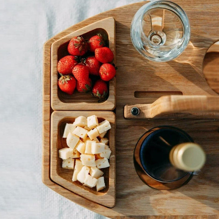 Bovenaanzicht van het houten blad met bakjes aardbeien en kaasblokjes, een wijnglas en een fles 5