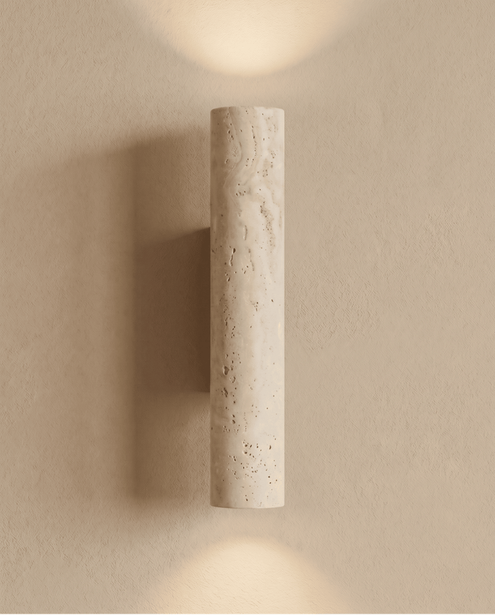 Rechtopstaande travertijnen wandlamp aan de muur, met lichtkegels naar boven en beneden en een schaduw links 7