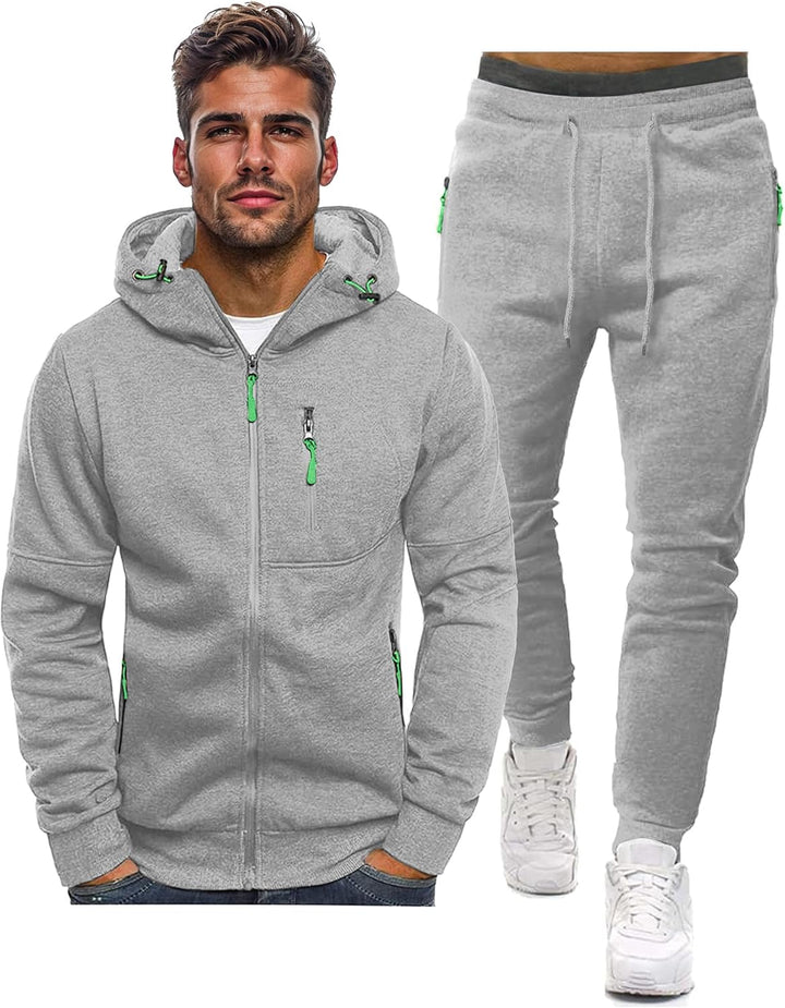 Lichtgrijs vest met capuchon en bijpassende joggingbroek naast elkaar, met groene ritstrekkers en trekkoorden 14