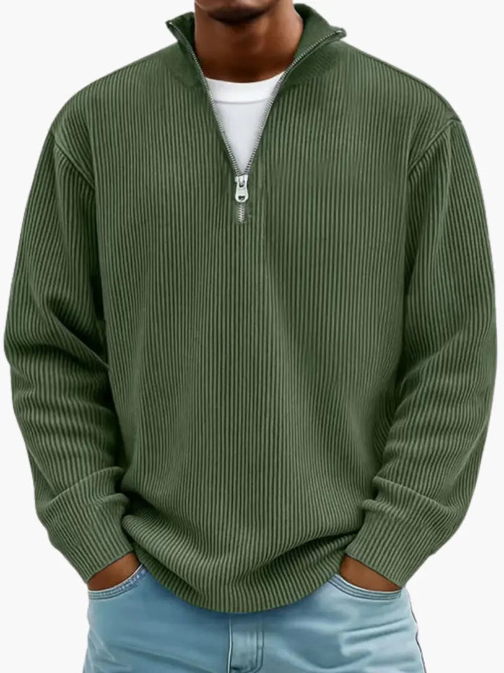 Model draagt de geribbelde trui met kwartrits in legergroen, met opstaande kraag en een wit shirt eronder. 8