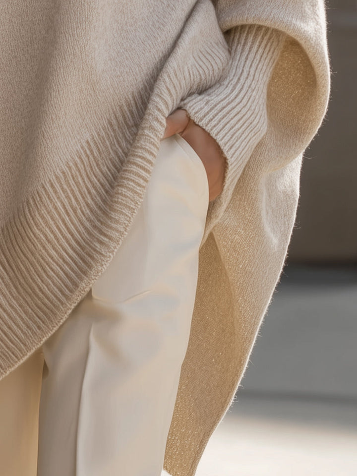 Detail van de zijsplit en geribbelde rand van de poncho, hand in de broekzak 6