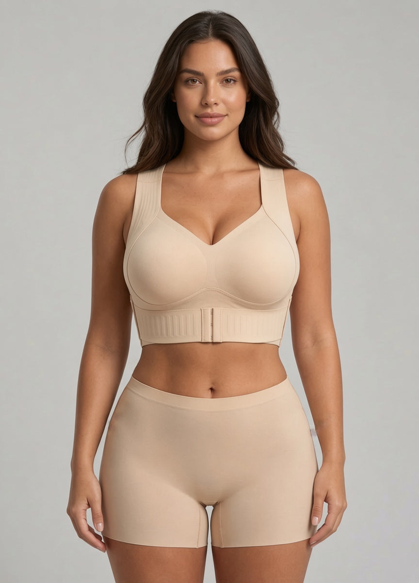Model draagt de beige steunbh met haakjes aan de voorkant en bijpassend naadloos boxershortje, frontaal gezien op grijze achtergrond. 1