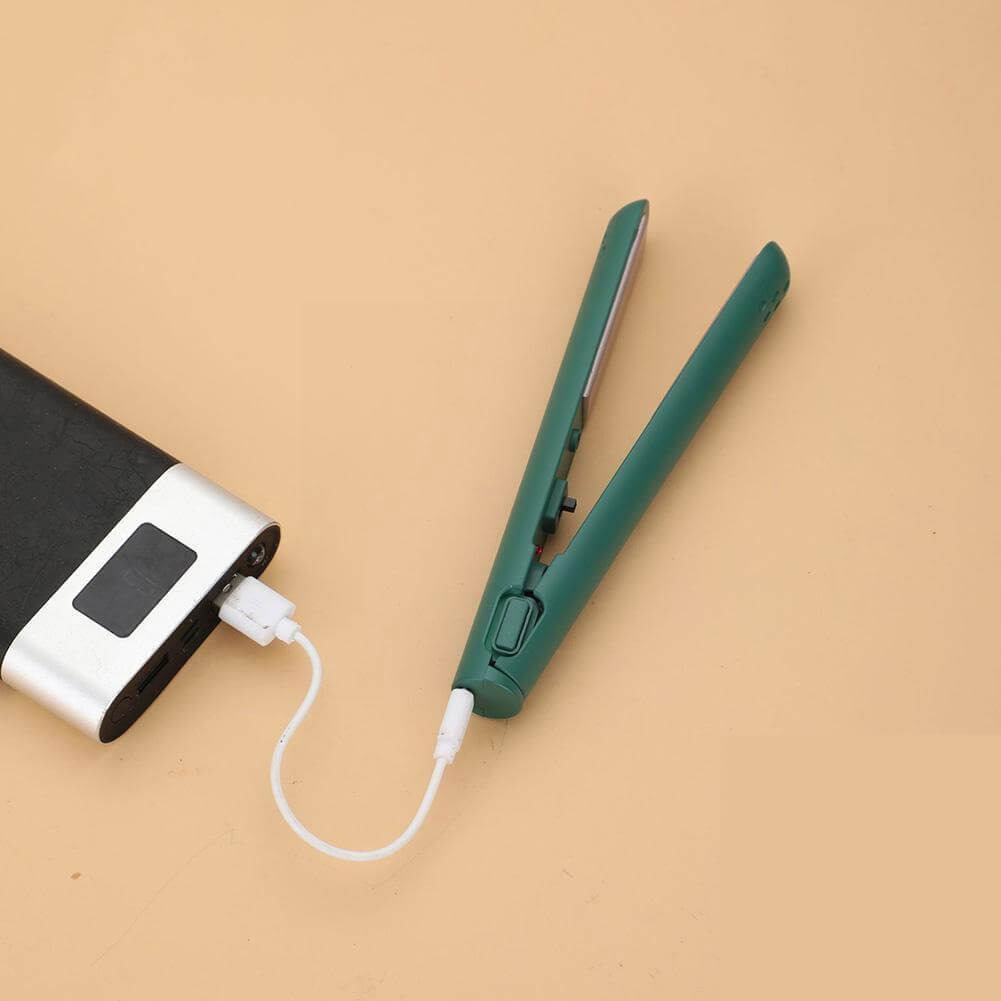 Groene mini-stijltang open op een perzikkleurige ondergrond, met wit usb-kabeltje verbonden met een zwarte powerbank met display. 11